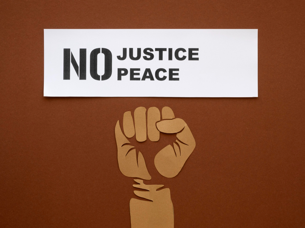 A raised fist beneath a sign reading No Justice No Peace